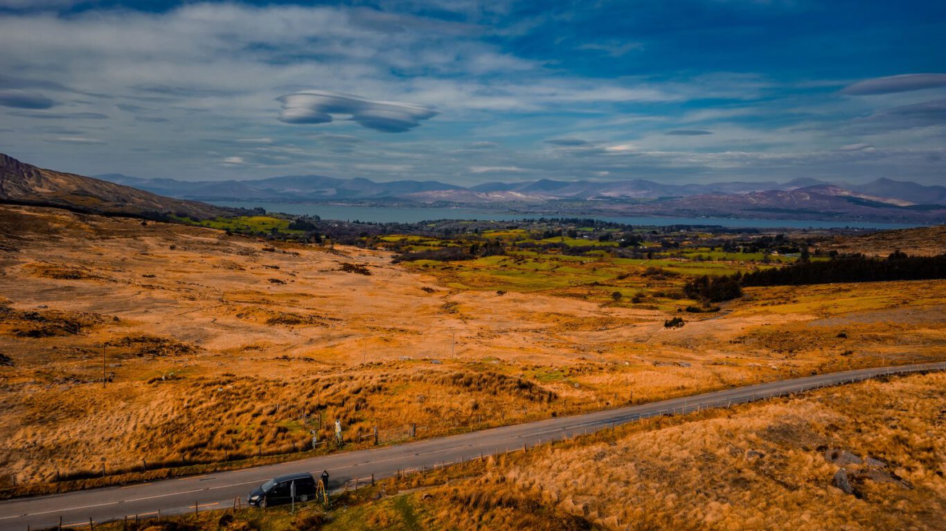 Weite irische Landschaft mit Bergen, See und Landstraße in County Kerry