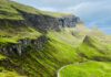 Grüne Berglandschaft und dramatische Felsen in den schottischen Highlands
