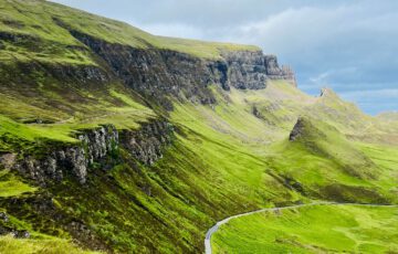 Grüne Berglandschaft und dramatische Felsen in den schottischen Highlands